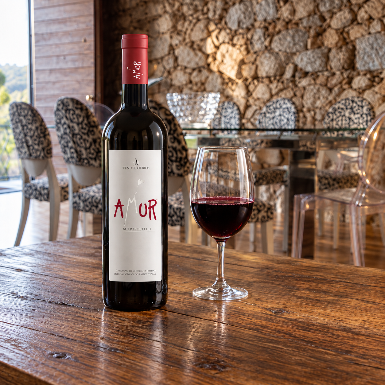 Tenute Olbios Amur Muristellu on a clear table with a normal glass of dark red wine