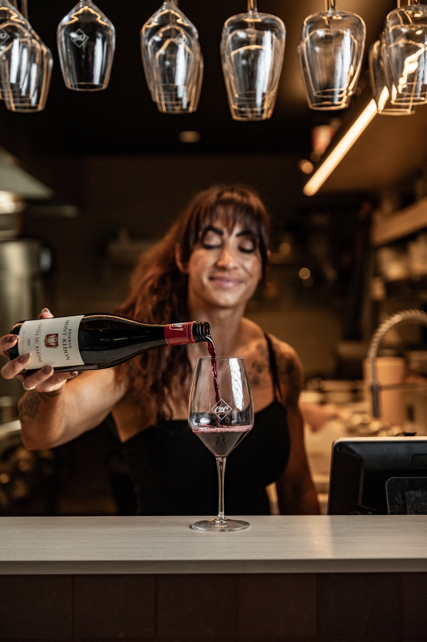 Alex pouring a restaurant-selected red wine behind the bar