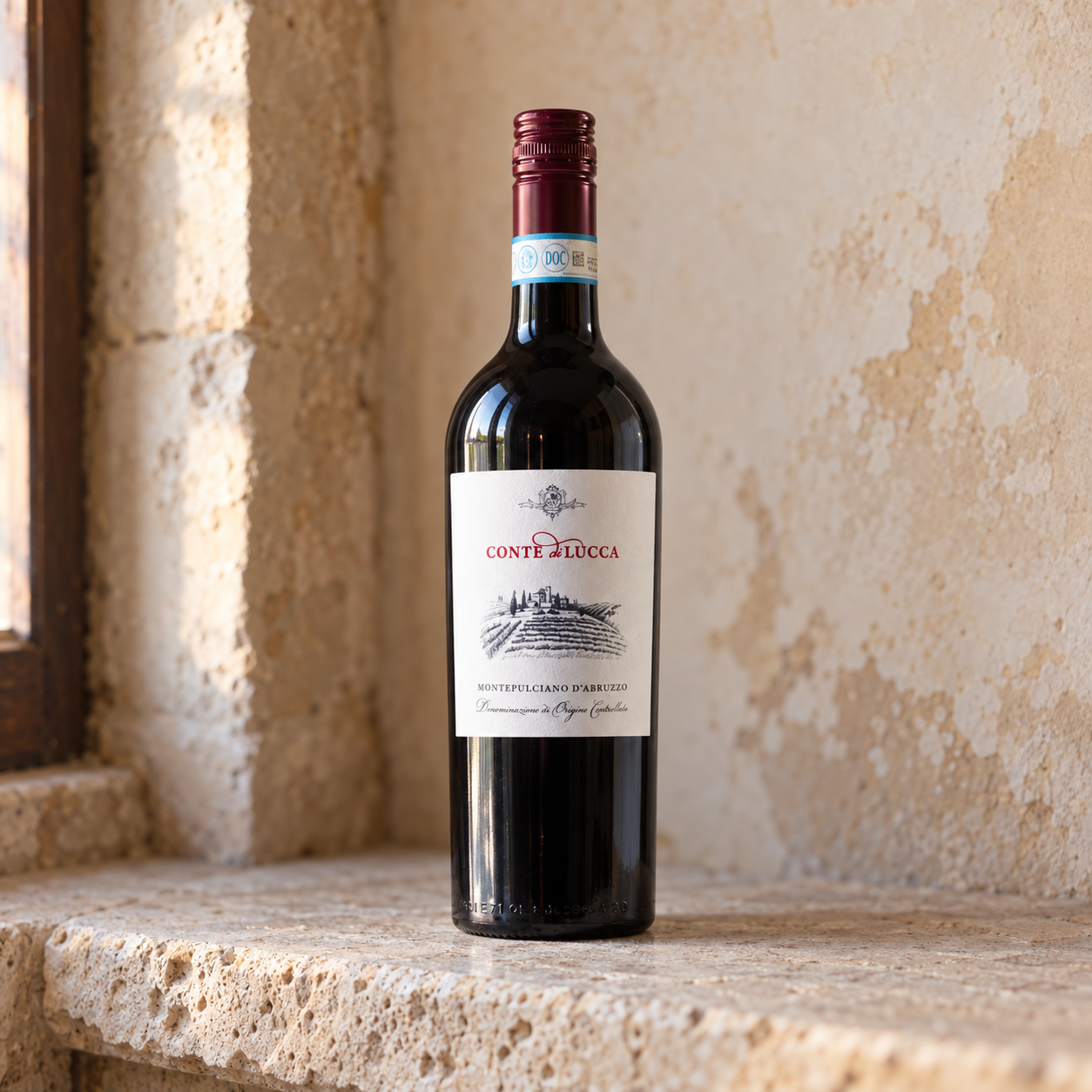 Conte di Lucca Montepulciano d'Abruzzo bottle and red wine in a natural Italian setting